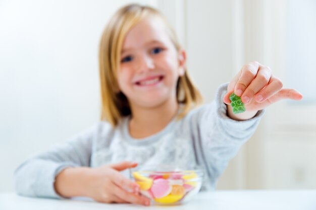 お菓子を家で食べる美しい子供。