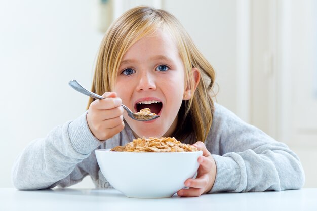 Beautiful child having breakfast at home.