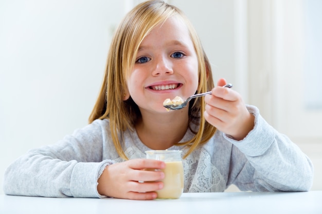 美しい子供は家で朝食をしています。