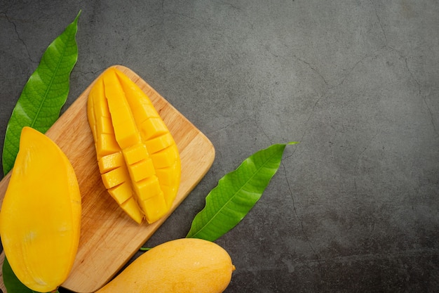 Beautiful chopped ripe mango on dark wooden surface