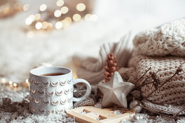 Free photo beautiful christmas cup with a hot drink on a light blurred background. the concept of home comfort and warmth.