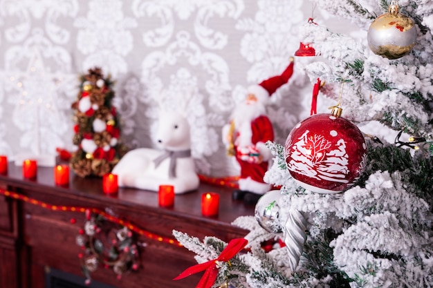 벽난로에 아름 다운 붉은 촛불과 함께 아름 다운 크리스마스 트리. 겨울이 왔습니다.