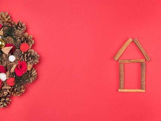 赤い背景に美しい家の装飾と美しいクリスマスリース。お祝いのインテリア