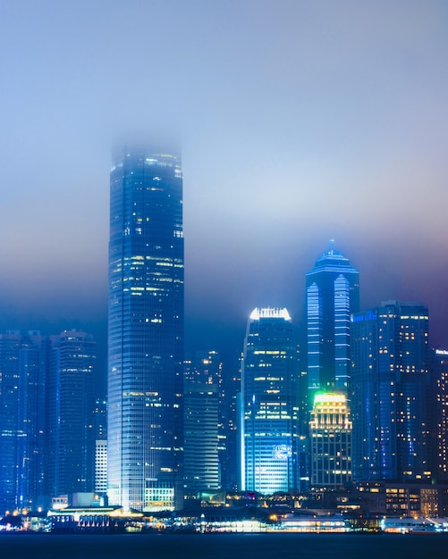 beautiful cityscape with illuminated building enveloped in fog in Hong Kong, China