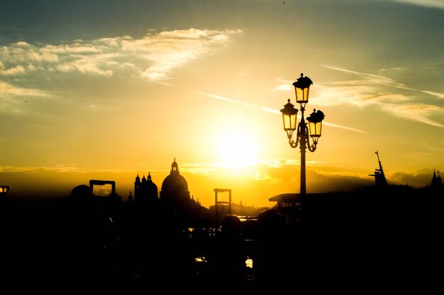 Beautiful cityscape with silhouettes of a street lamp and buildings in the sunset