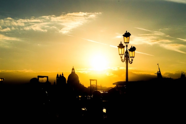 Beautiful cityscape with silhouettes of a street lamp and buildings in the sunset