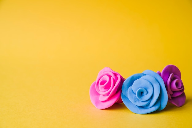 Beautiful clay roses on yellow backdrop