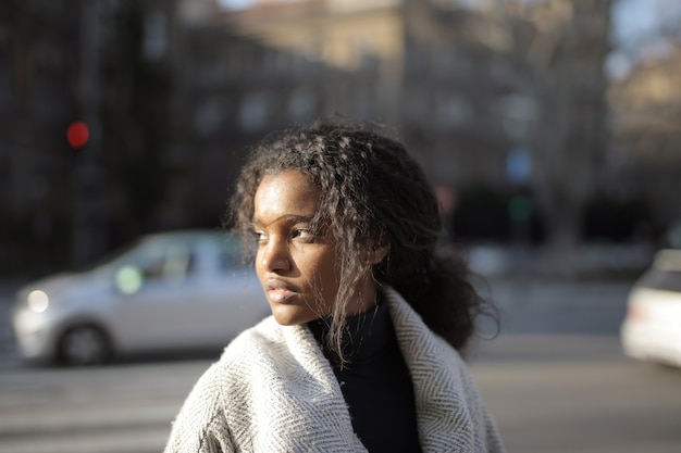 Bellissimo primo piano di una ragazza afroamericana con i capelli ricci su uno sfondo sfocato