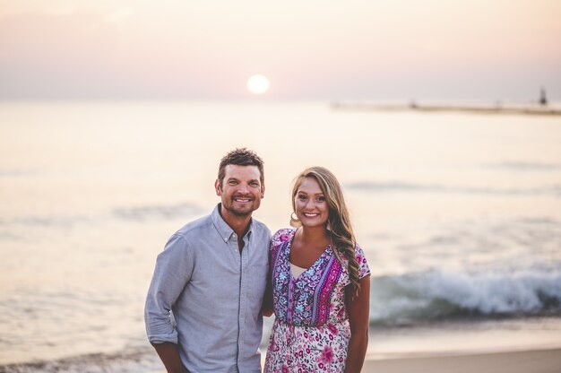 Beautiful closeup portrait of a young couple posing in front of a stunning seascape