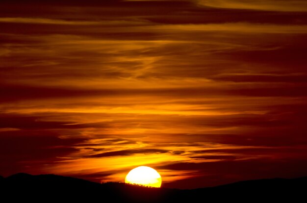 イタリア、トスカーナの空と半分の太陽を読んだ夕日の美しいクローズアップショット