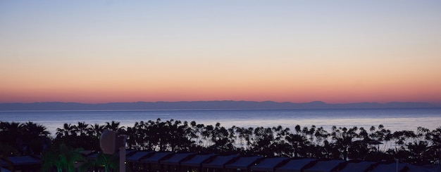 海と太陽に沈む美しいカラフルな夕日。オレンジ色の空。