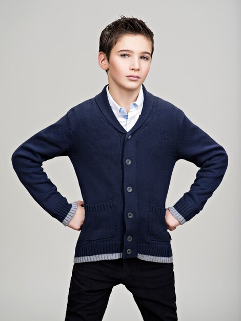 Beautiful   confident teenage boy posing at studio as a fashion model.