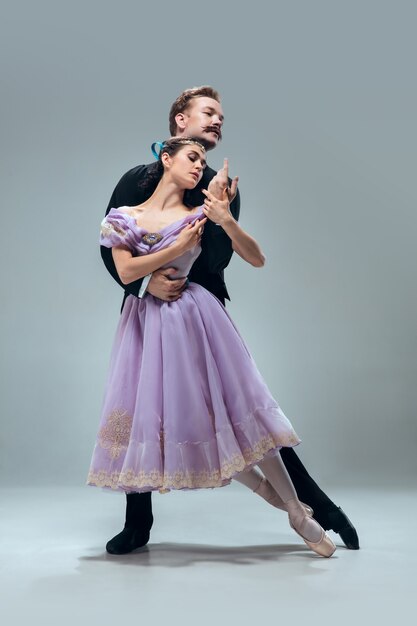 Beautiful contemporary ballroom dancers isolated on grey studio wall