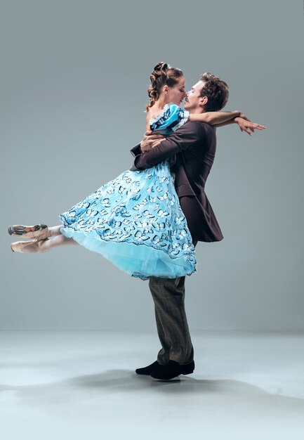 Beautiful contemporary ballroom dancers isolated on grey studio wall