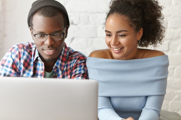 Free photo beautiful couple at a cafe with laptop