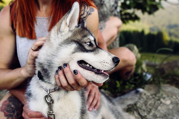 Beautiful couple and a dog have a rest near a tree