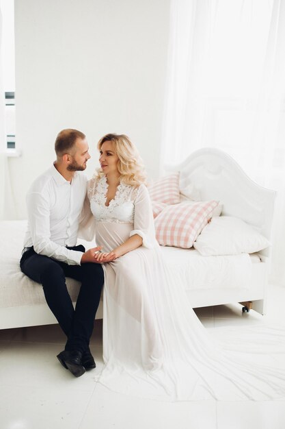 Beautiful couple embracing stomach and touching face to face