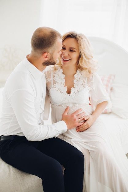 Beautiful couple embracing stomach and touching face to face