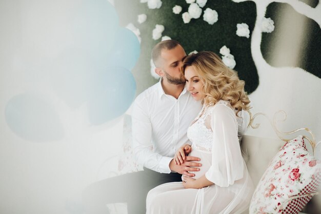 Beautiful couple embracing stomach and touching face to face