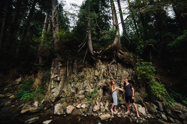 Beautiful couple hugging each other near a mountain river