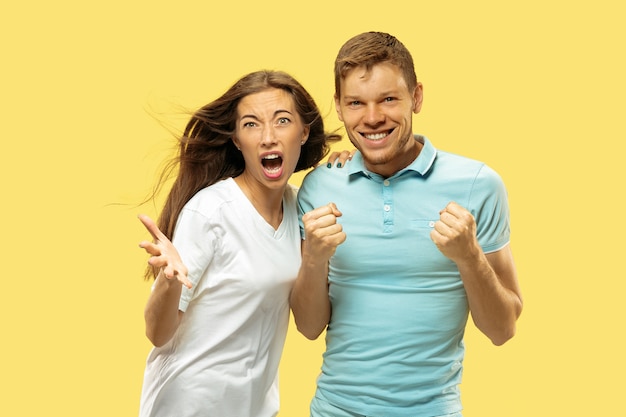 Beautiful couple isolated on yellow studio background