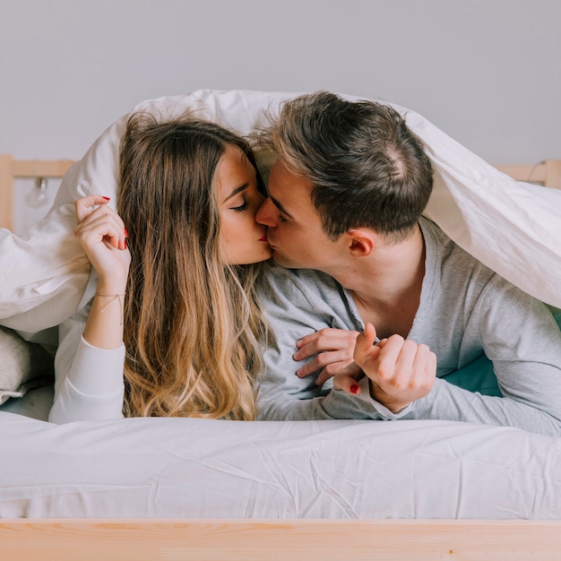 침대에 키스하는 아름 다운 커플