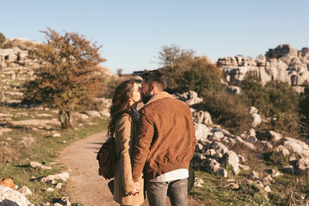 自然の中でキスする美しいカップル