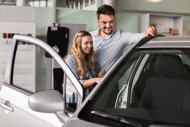 Beautiful couple looking at a car