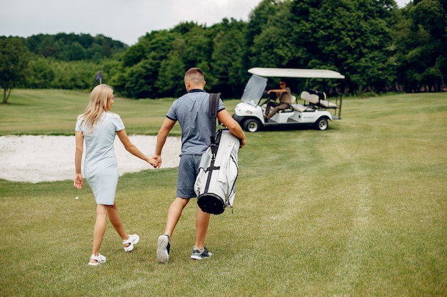 골프 코스에서 골프를 재생하는 아름 다운 커플