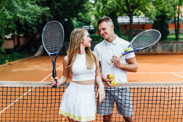 Красивая пара играет в теннис и выглядит счастливой друг с другом.