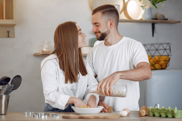 美しいカップルは、キッチンで食事を準備します