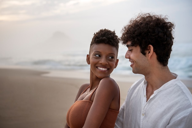 Free photo beautiful couple showing affection on the beach near the ocean