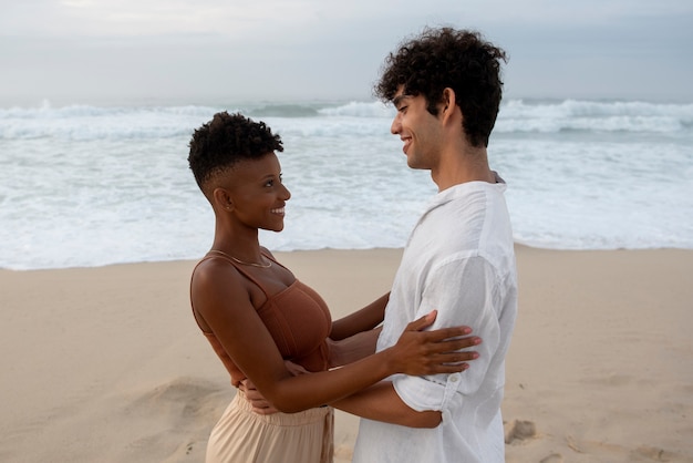 Free photo beautiful couple showing affection on the beach near the ocean