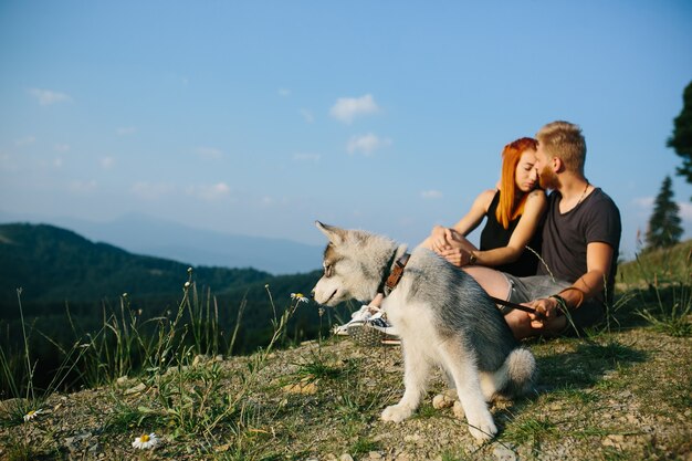 Beautiful couple sits on a hill and hugging each other