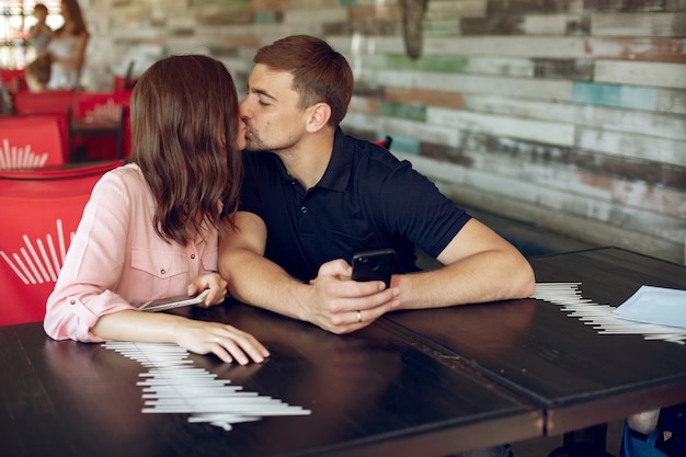 Free photo beautiful couple sitting in a summer cafe