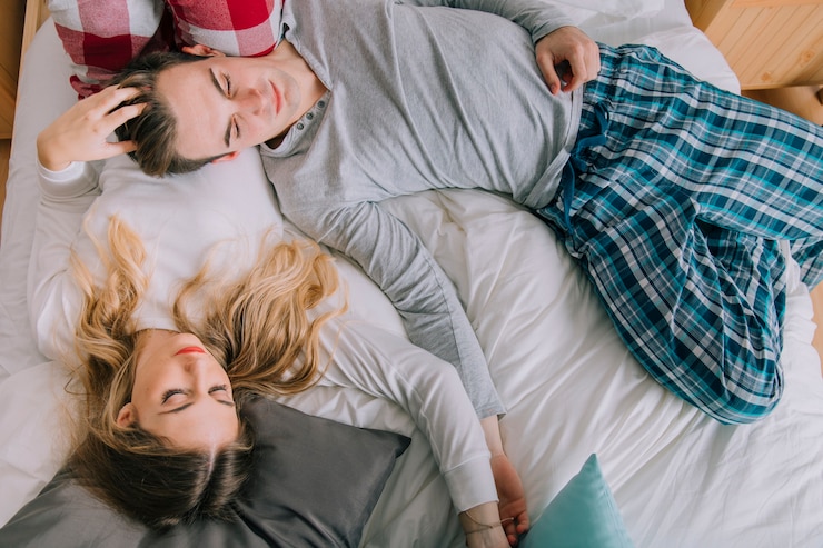 Free Photo beautiful couple sleeping on bed