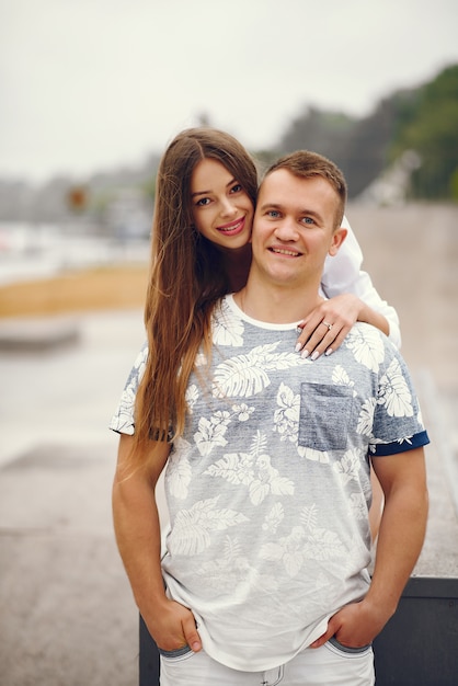 Free photo beautiful couple spend time in a autumn cloudy park