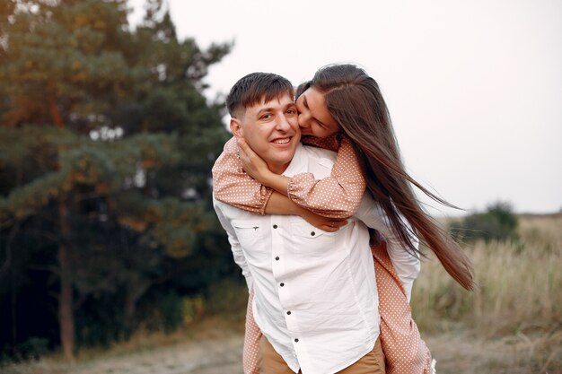 Beautiful couple spend time on a autumn field