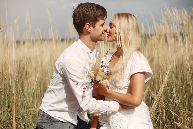 Beautiful couple spend time in a autumn field