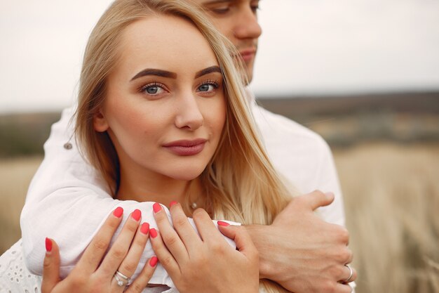 Beautiful couple spend time in a autumn field