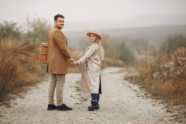 Beautiful couple spend time in a autumn field