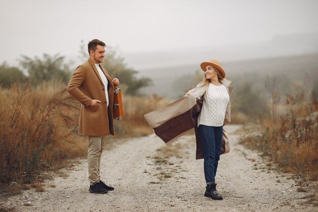 Beautiful couple spend time in a autumn field