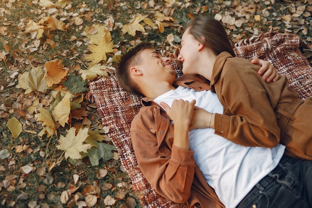 Foto gratuita le belle coppie trascorrono il tempo in un parco di autunno