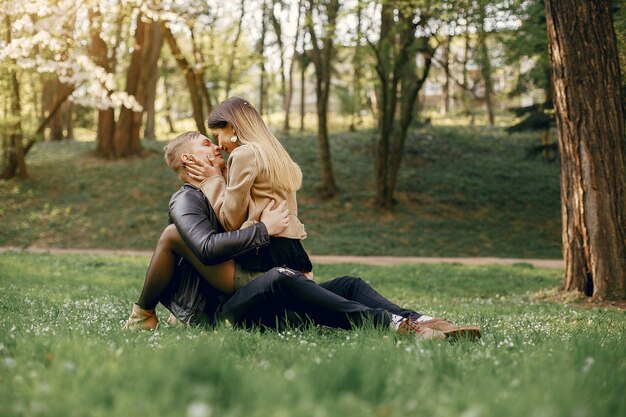 美しいカップルは春の公園で時間を過ごします