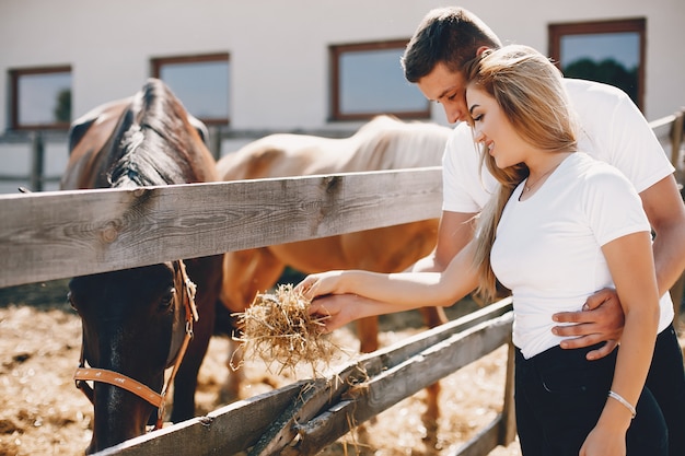 Beautiful couple spend time with a horses