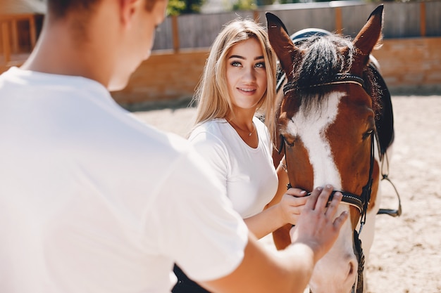 Beautiful couple spend time with a horses