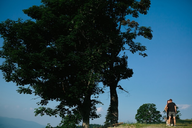 Beautiful couple standing on a hill and gently hugging each other