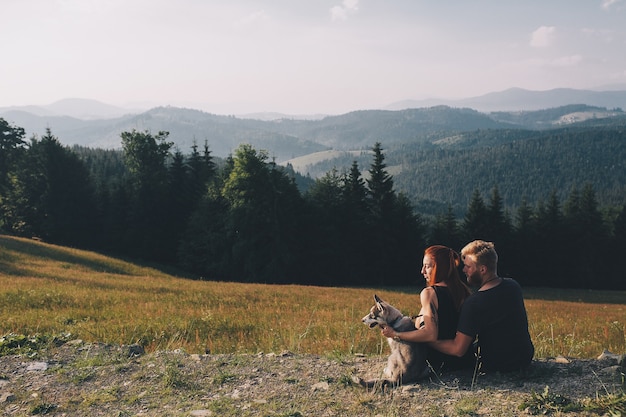 Foto gratuita bella coppia in piedi su una collina e guarda in lontananza