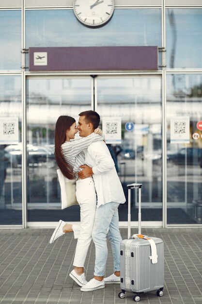 공항 근처에 서있는 아름 다운 커플