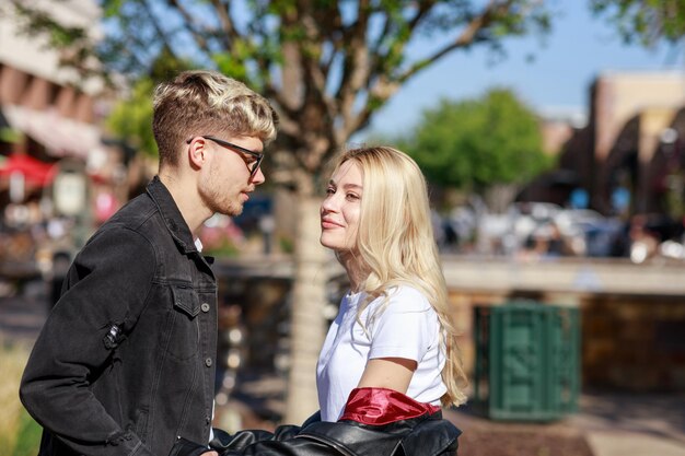 A beautiful couple standing on at the park and looking at each other on a sunny day High quality photo